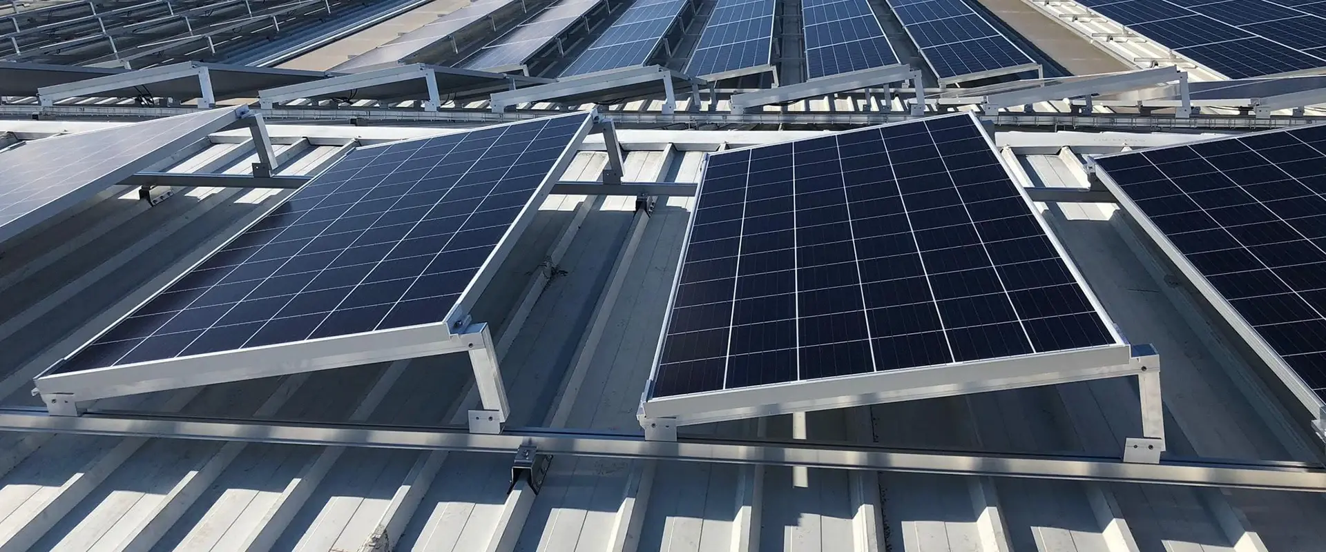 Sistema de soporte fotovoltaico tipo coplanar e inclinado instalado sobre cubierta metálica grecada, con perfiles estructurales de aluminio.