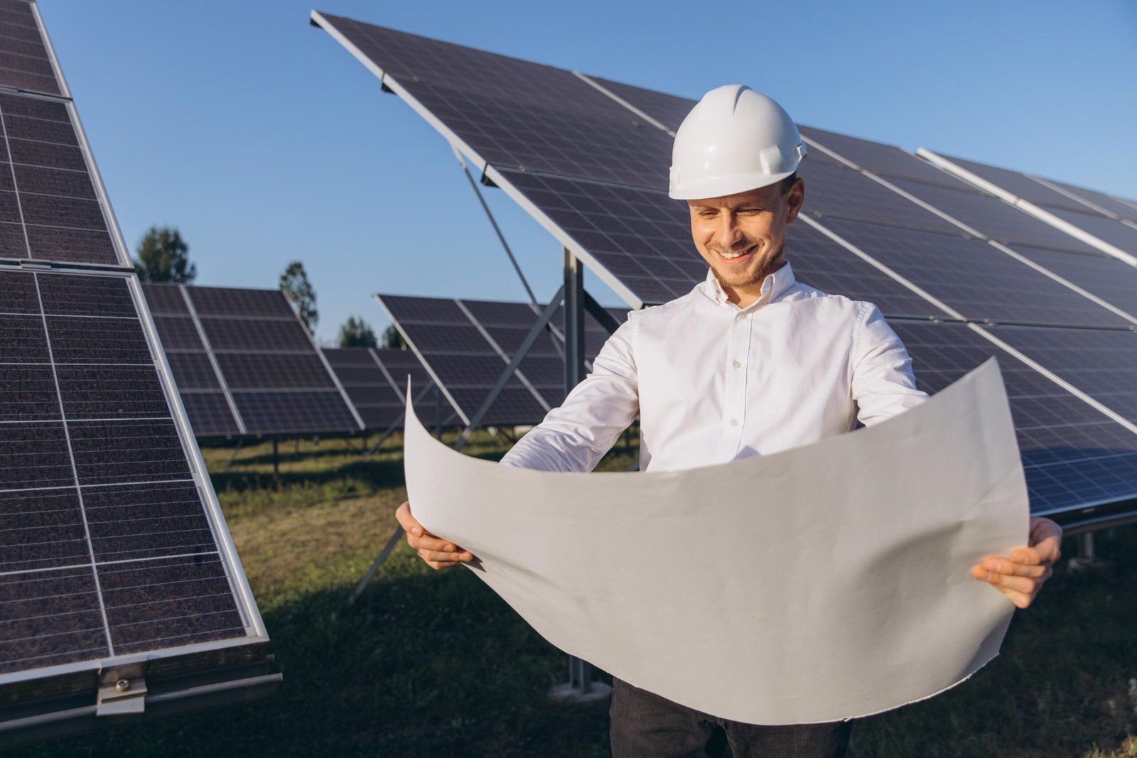 Ingeniero revisando planos en una instalación de paneles solares fotovoltaicos al aire libre